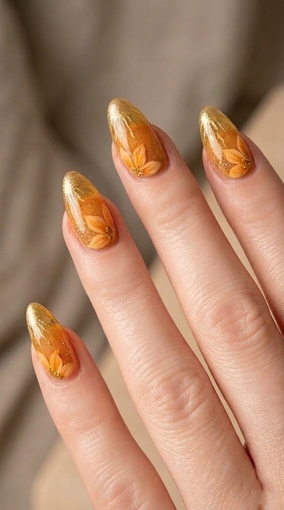 Amber translucent nails with marigold flower near cuticle and molten gold chrome drip tips