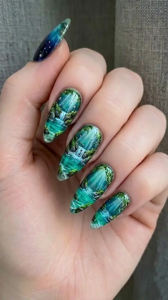 waterfall and emerald forest landscape nail art with sunbeams on long almond nails