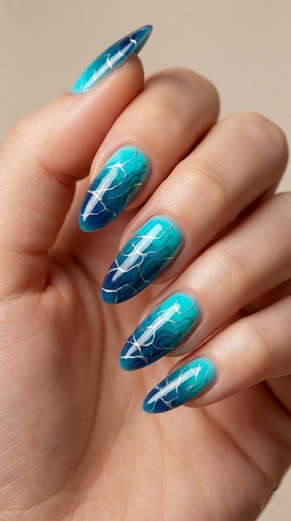 Water marble almond nails in deep navy teal and turquoise with silver metallic veining