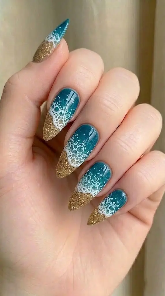 teal to gold shoreline gradient nails with white seafoam lace detail on long almond nails