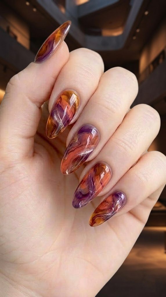 Tortoiseshell marble almond nails swirling amber terracotta and violet purple with silver glitter veins