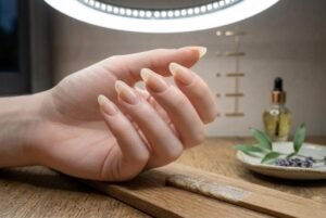 Long natural fingernails in almond shape showing healthy nail plate and free edge length