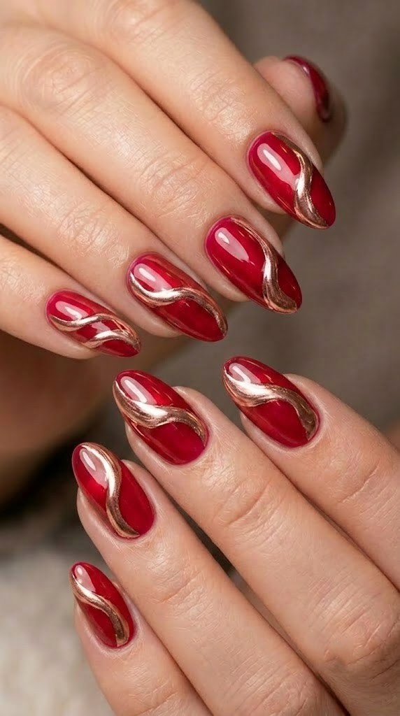Cranberry glaze nails swept with rose gold waves, striking autumn nail colors