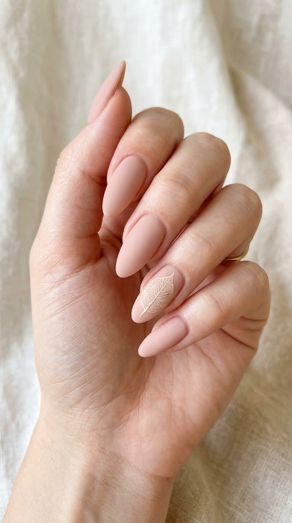 A whisper-thin leaf skeleton floats across nude-pink nails, poetic September nail ideas inspiration.